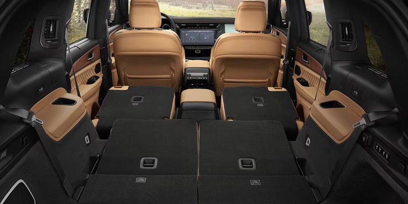 A spacious SUV interior with tan leather front seats and all rear seats folded flat for maximum cargo space