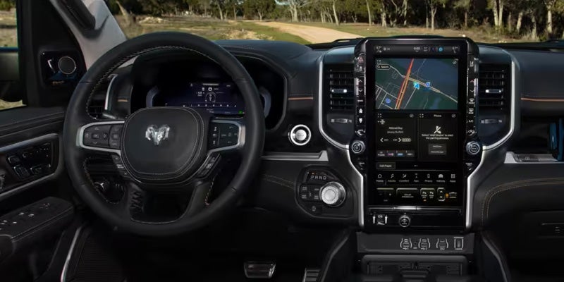 Interior of a truck cabin, with a large central dashboard touchscreen displaying a map and controls
